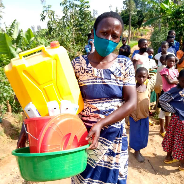 A woman from the community receiving food and other materials from the Ngoboka Project